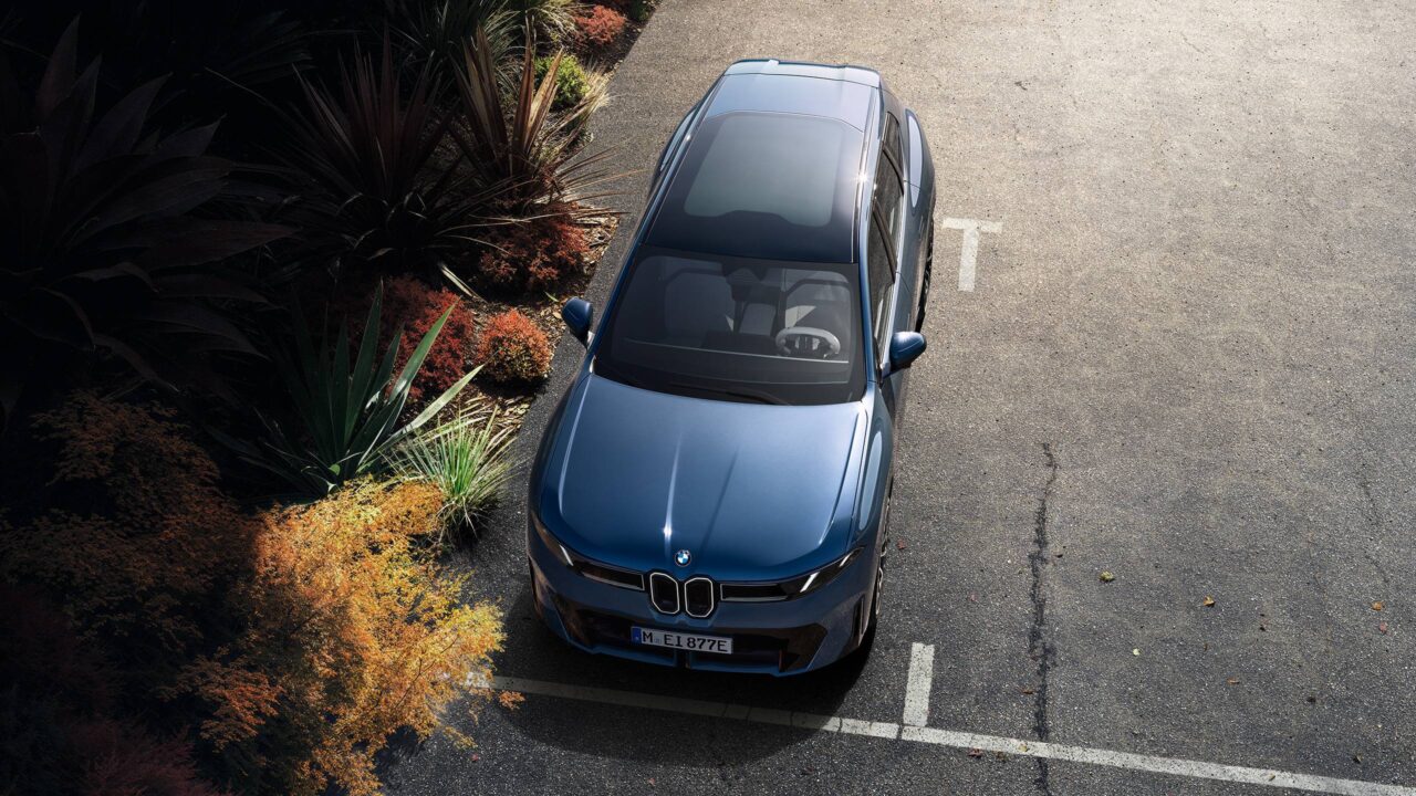 De nieuwe BMW iX3 naast de bosjes